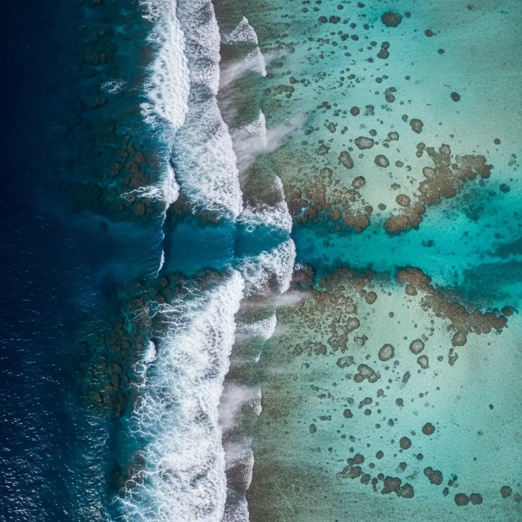 Aerial view of New Caledonia barrier reef showing offshore wind spray